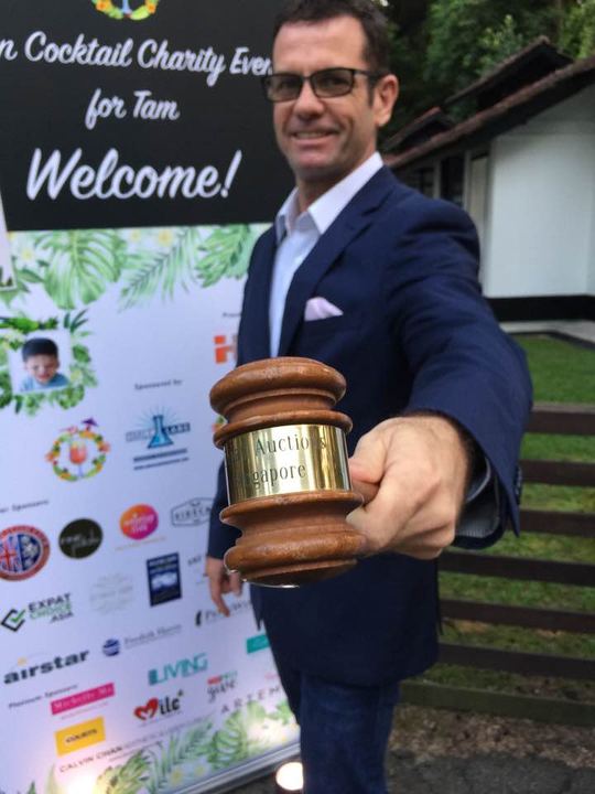 Gavel in hand at a charity cocktail event