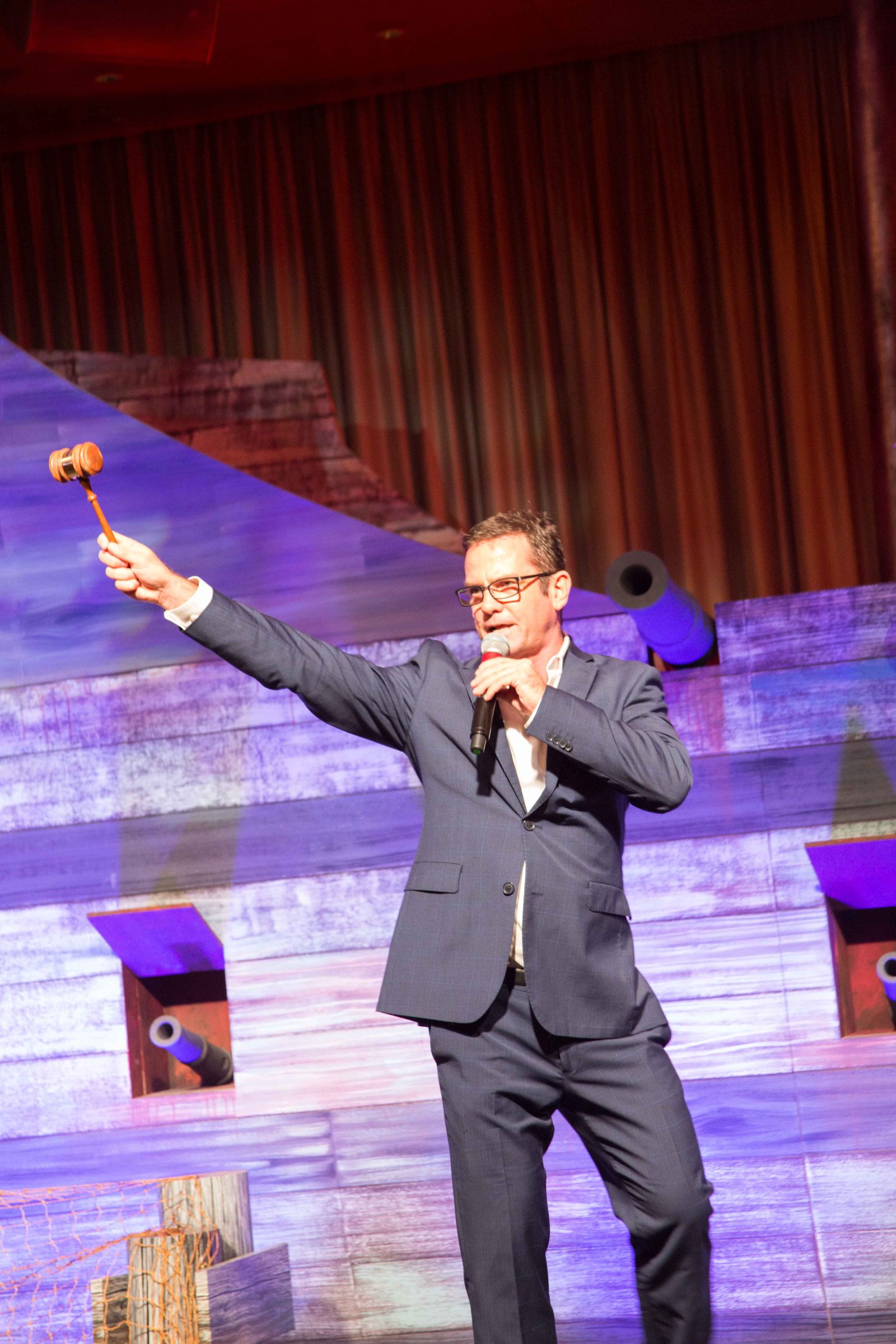 Auctioneer Shaun McEwan with gavel in hand on stage